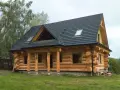 Piękny dom z bali, który budzi pytanie: czy dom z bali trzeba ocieplać? Grube bale zapewniają naturalną izolację.