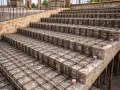 Siatka z prętów na zbrojenie schodów, gotowa do zalania betonem. Widać kolejne stopnie i ich konstrukcję.