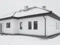 Nowoczesny, biały budynek wolnostojący z dachem pokrytym śniegiem. Wokół domu leży śnieg, tworząc zimową scenerię.