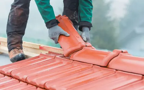 Dachówka ceramiczna w trakcie montażu. Wymiana dachu wymaga pozwolenia, ale efekt końcowy jest wart wysiłku.