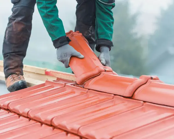 Dachówka ceramiczna w trakcie montażu. Wymiana dachu wymaga pozwolenia, ale efekt końcowy jest wart wysiłku.