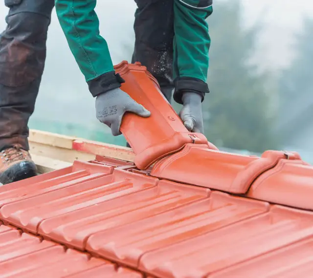 Dachówka ceramiczna w trakcie montażu. Wymiana dachu wymaga pozwolenia, ale efekt końcowy jest wart wysiłku.